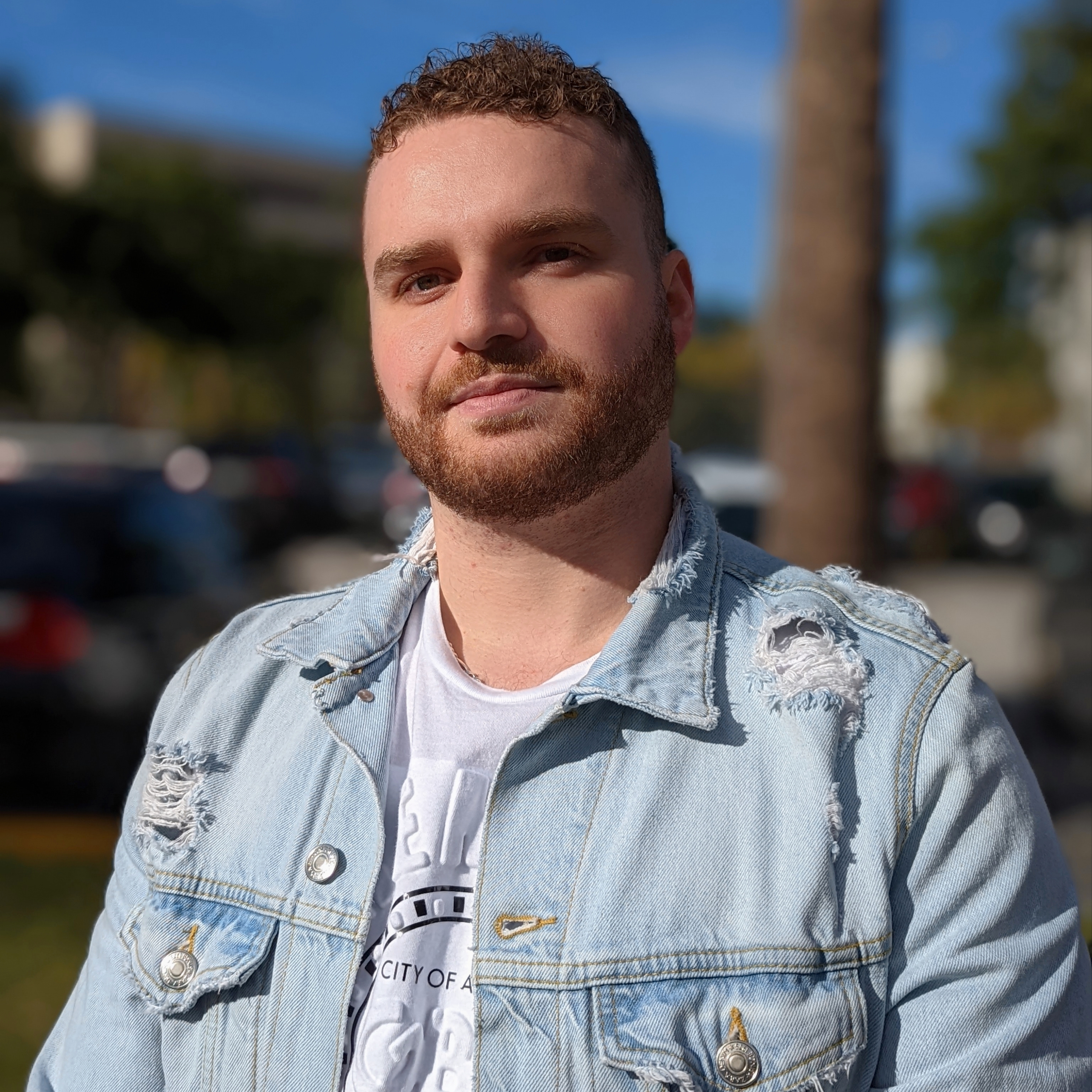 David, a university student outside looking at the camera wearing a light blue sweater